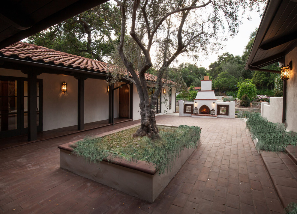 Mid-sized mediterranean courtyard patio in Santa Barbara with natural stone pavers.