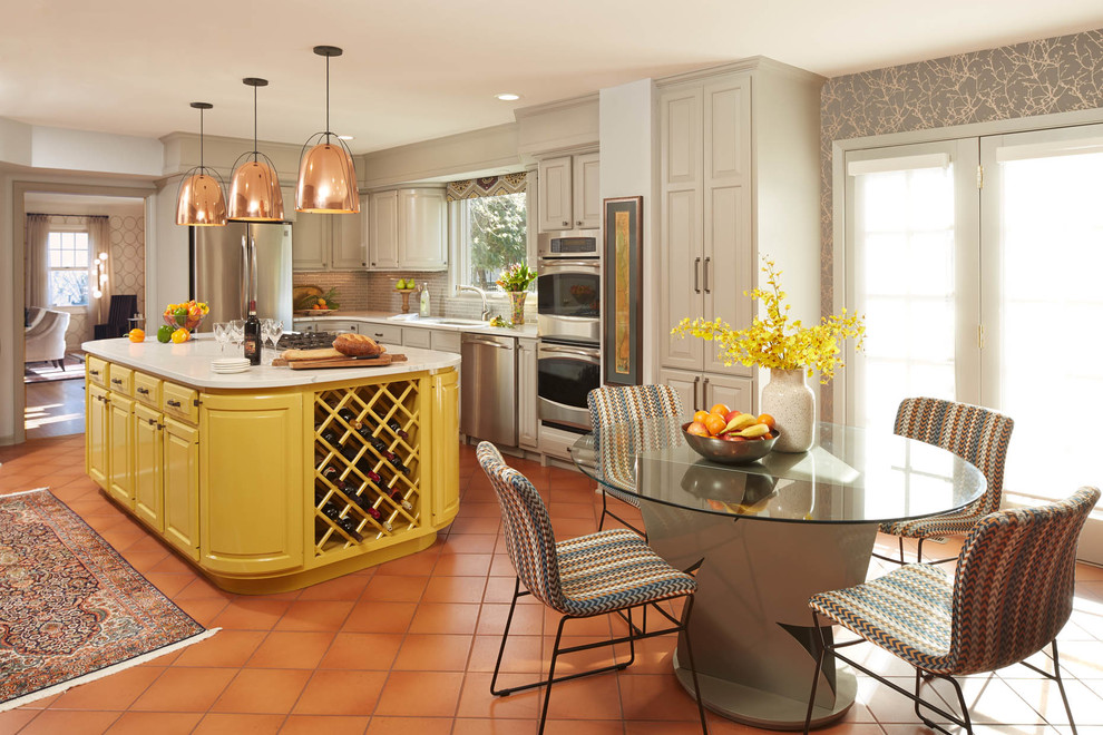 Eclectic l-shaped eat-in kitchen in Minneapolis with an undermount sink, raised-panel cabinets, beige cabinets, beige splashback, stainless steel appliances, terra-cotta floors, with island, orange floor and white benchtop.