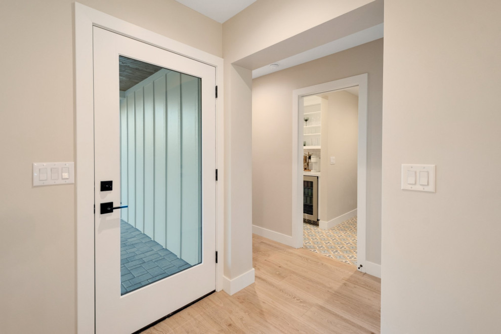 Example of a large transitional l-shaped porcelain tile and beige floor kitchen pantry design in Phoenix with a farmhouse sink, shaker cabinets, white cabinets, quartz countertops, white backsplash, ceramic backsplash, stainless steel appliances, an island and white countertops