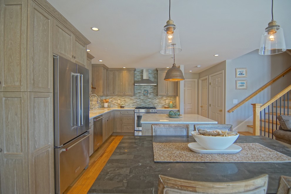 Mid-sized transitional l-shaped medium tone wood floor and beige floor eat-in kitchen photo with an undermount sink, beaded inset cabinets, distressed cabinets, marble countertops, gray backsplash, ceramic backsplash, stainless steel appliances, an island and white countertops