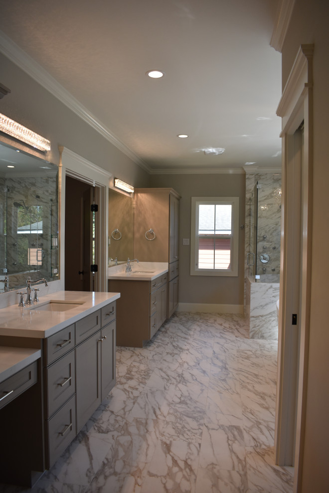 Photo of an arts and crafts master bathroom in Houston with recessed-panel cabinets, grey cabinets, a freestanding tub, a corner shower, a two-piece toilet, gray tile, porcelain tile, grey walls, porcelain floors, an undermount sink, engineered quartz benchtops, a hinged shower door, grey benchtops, a shower seat, a double vanity and a built-in vanity.