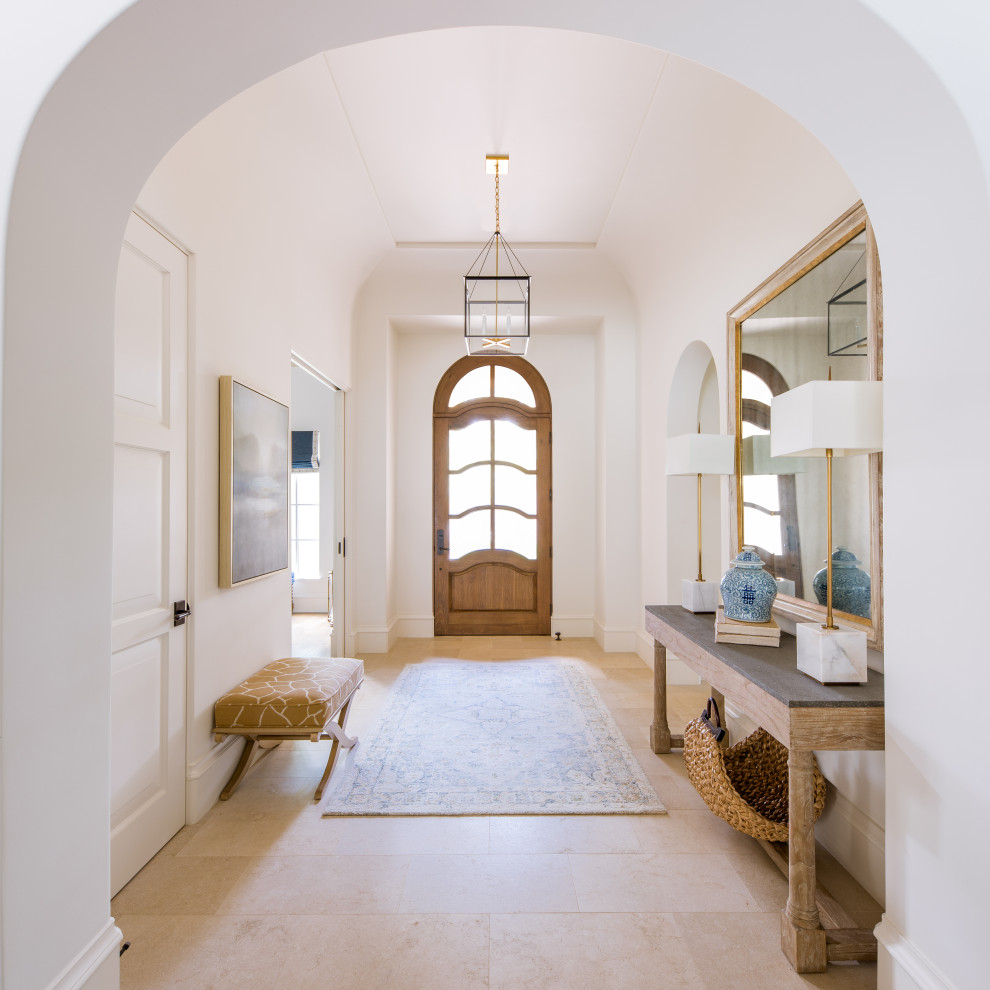 Photo of a foyer in Dallas with white walls, a single front door, a medium wood front door and beige floor.