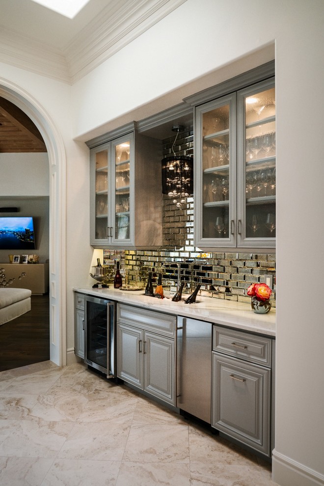 Inspiration for an expansive traditional single-wall wet bar in San Diego with an undermount sink, recessed-panel cabinets, grey cabinets, quartz benchtops, multi-coloured splashback, mirror splashback, travertine floors, beige floor and white benchtop.