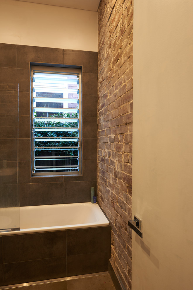 This is an example of a small contemporary master bathroom in Sydney with a shower/bathtub combo, gray tile, ceramic tile, brown walls and ceramic floors.