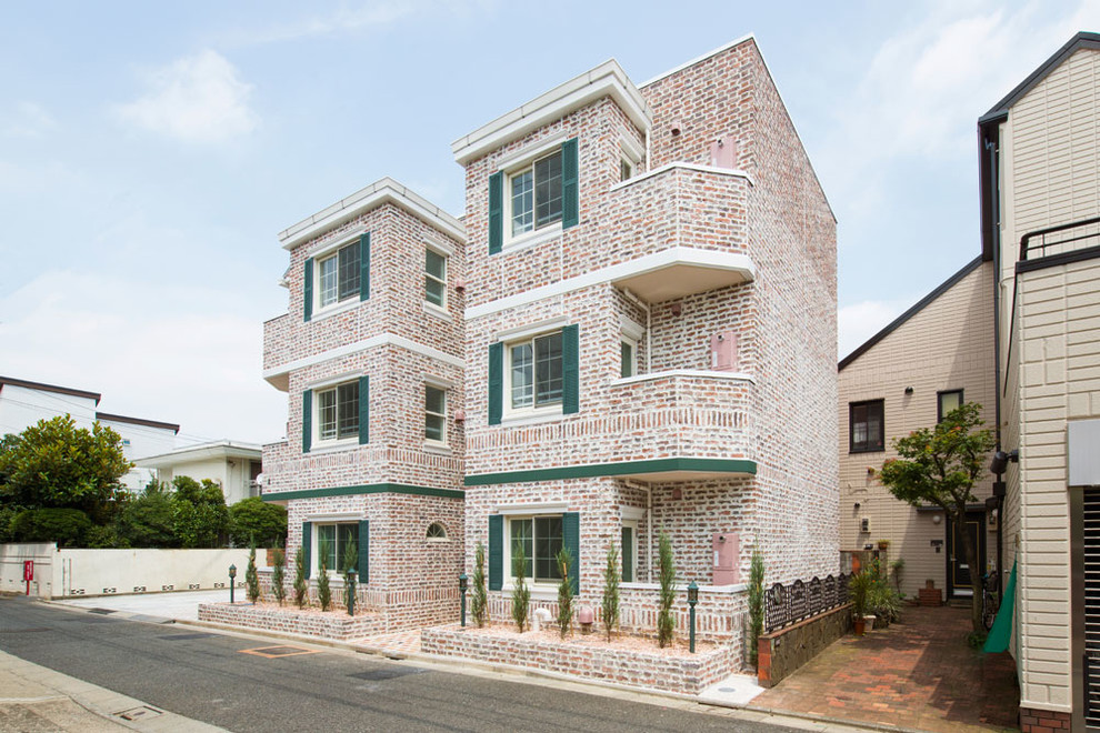 Inspiration for a large traditional three-storey brick pink apartment exterior in Tokyo.