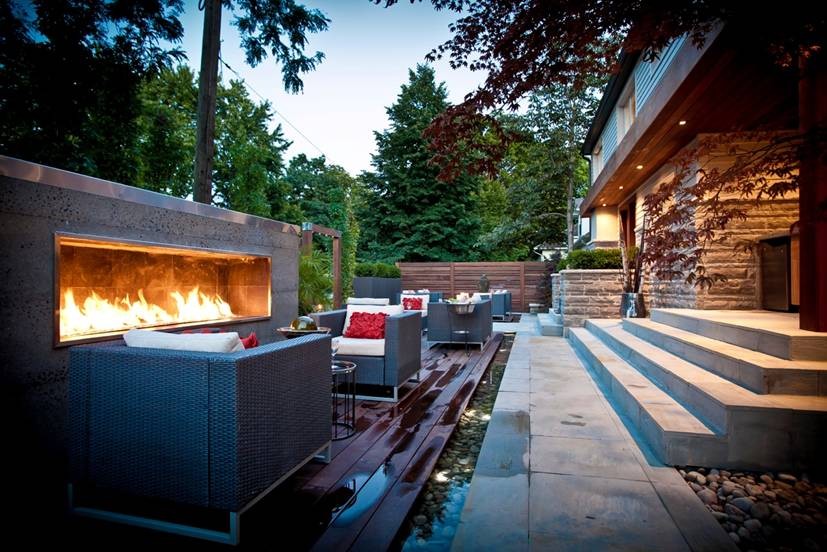 Photo of a mid-sized modern backyard patio in Toronto with a fire feature, decking and no cover.