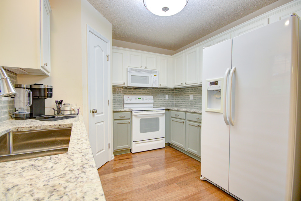 Mid-sized transitional u-shaped medium tone wood floor and brown floor eat-in kitchen photo with an undermount sink, shaker cabinets, green cabinets, granite countertops, green backsplash, ceramic backsplash, white appliances, no island and multicolored countertops