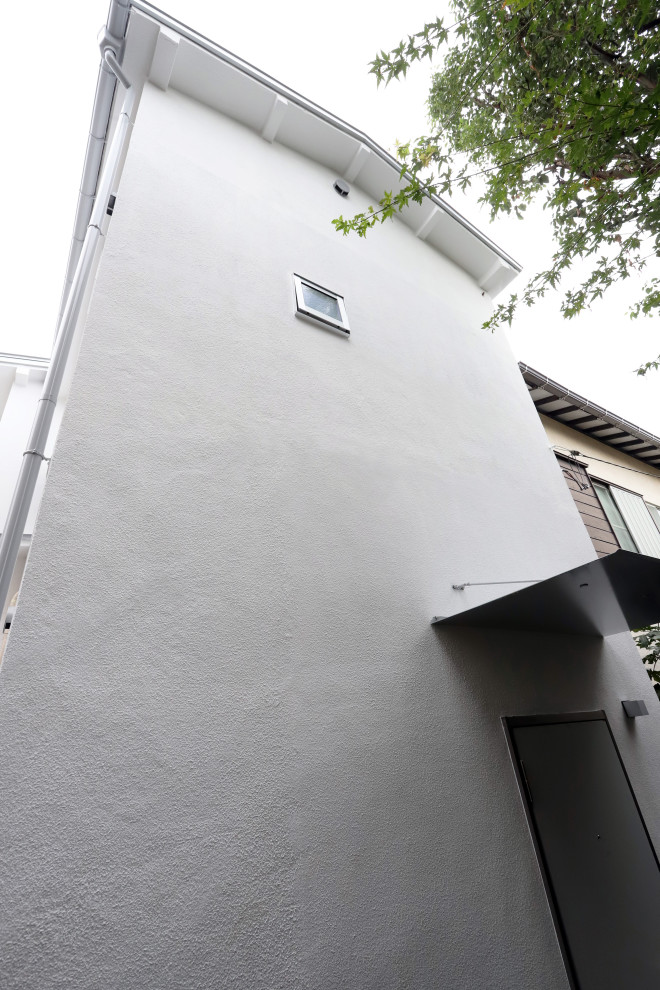 東京都下にある小さなおしゃれな二階建ての家 (漆喰サイディング) の写真
