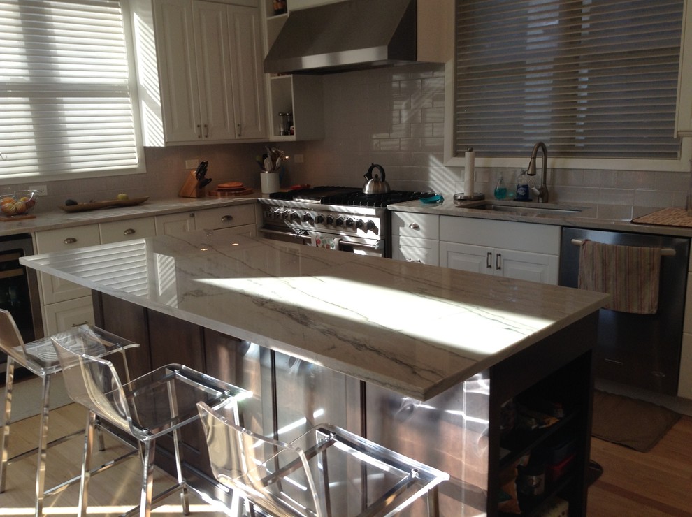 Eat-in kitchen - transitional light wood floor eat-in kitchen idea in Chicago with raised-panel cabinets, white cabinets, marble countertops, subway tile backsplash and an island