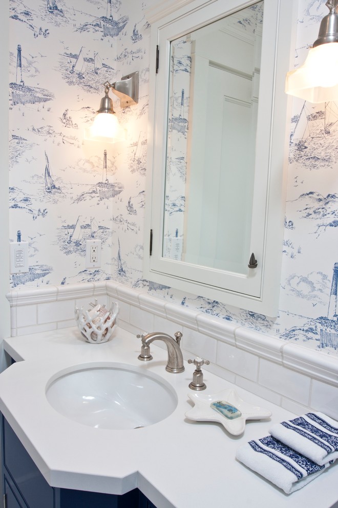 Photo of a mid-sized beach style 3/4 bathroom in San Diego with an undermount sink, blue cabinets, white tile, multi-coloured walls, solid surface benchtops, flat-panel cabinets and subway tile.