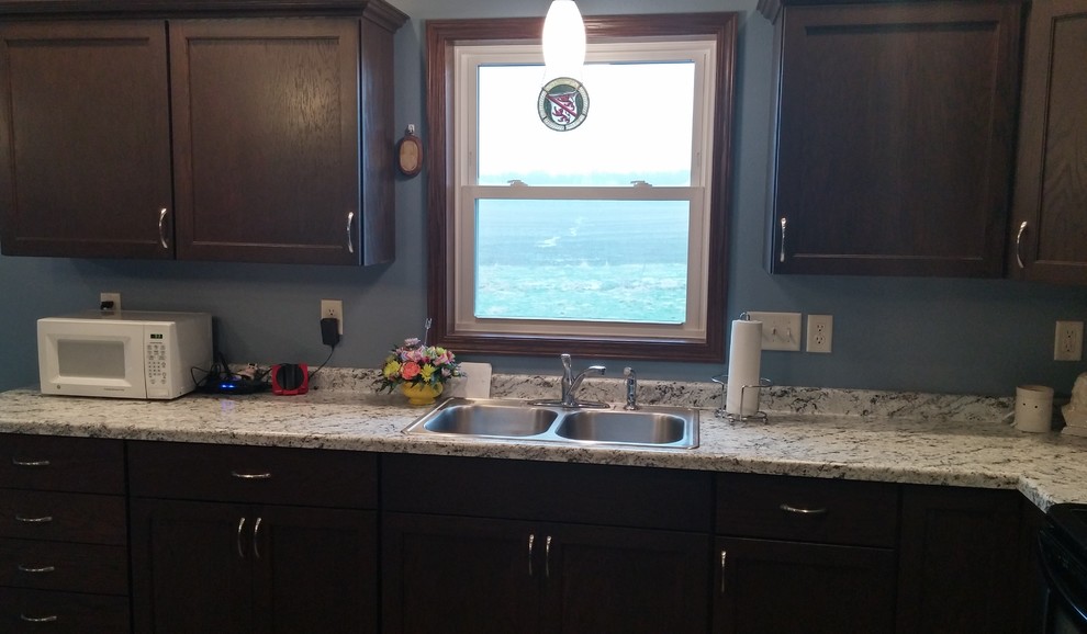 Transitional l-shaped home design photo with a drop-in sink, shaker cabinets, laminate countertops and an island