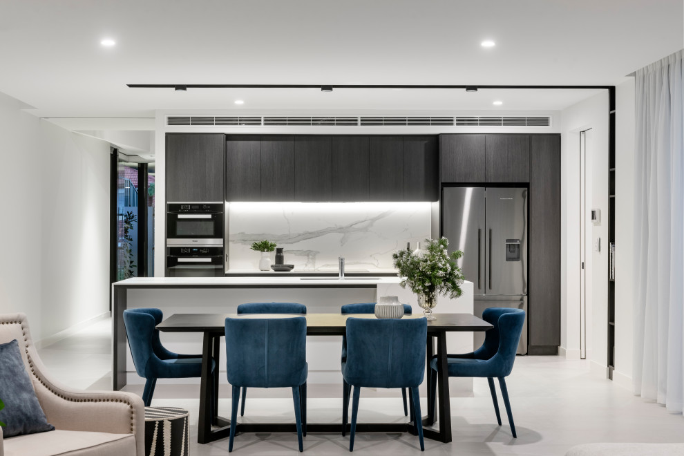 Mid-sized contemporary galley eat-in kitchen in Perth with an undermount sink, flat-panel cabinets, dark wood cabinets, white splashback, stainless steel appliances, with island, white floor and white benchtop.