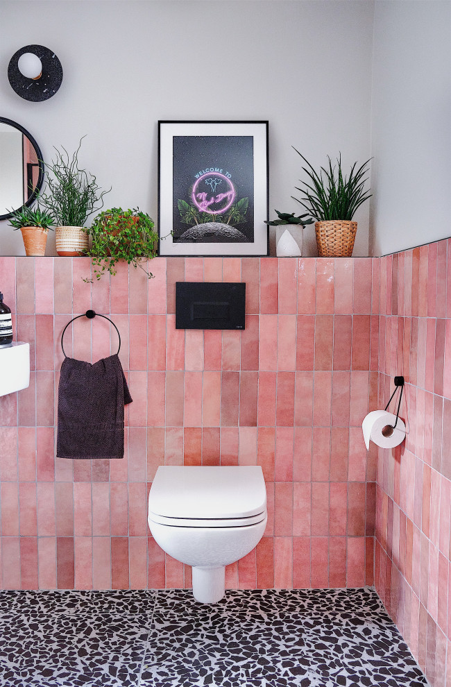 Design ideas for a mid-sized contemporary kids bathroom in London with black cabinets, an open shower, a wall-mount toilet, pink tile, ceramic tile, white walls, terrazzo floors, a trough sink, black floor, an open shower, a niche and a single vanity.