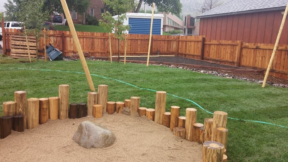 Mid-sized backyard full sun outdoor sport court in Denver with with outdoor playset and natural stone pavers for summer.