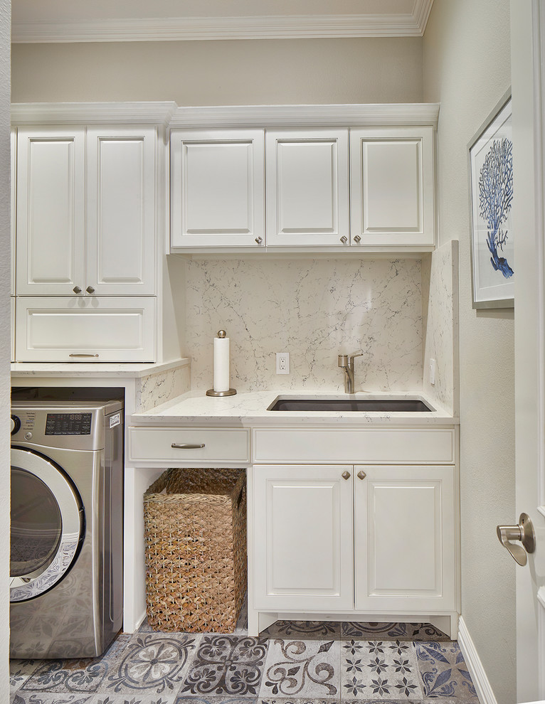 Photo of a small transitional laundry room in Dallas with an undermount sink, porcelain floors, a side-by-side washer and dryer, multi-coloured floor and white benchtop.