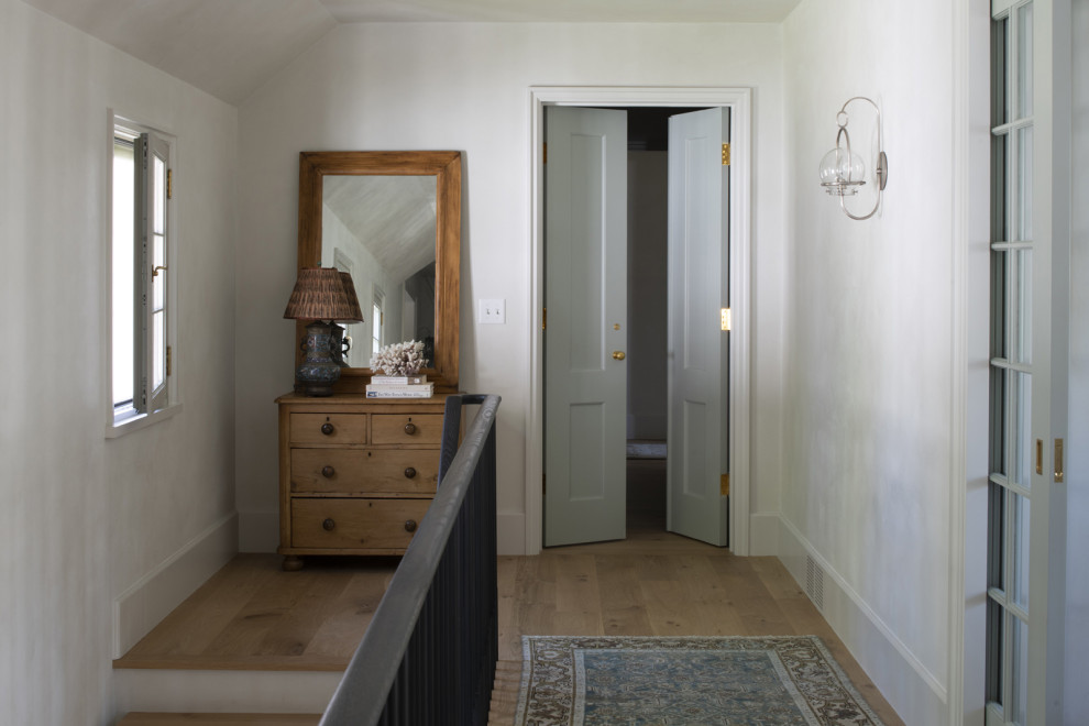 Design ideas for a hallway in Minneapolis with white walls and medium hardwood floors.