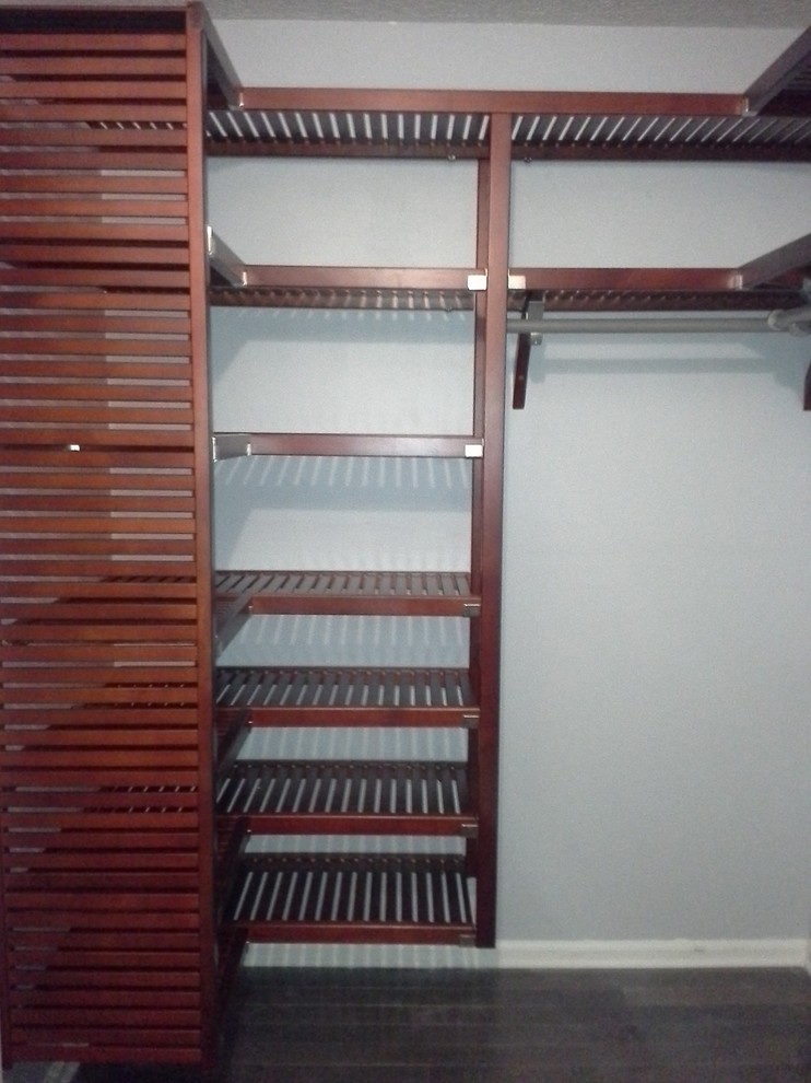 Photo of a mid-sized traditional gender-neutral walk-in wardrobe in Jacksonville with louvered cabinets and dark wood cabinets.