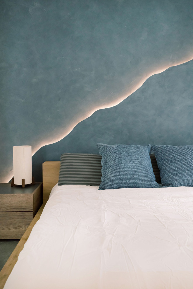 オースティンにある中くらいなコンテンポラリースタイルのおしゃれな主寝室 (青い壁、コンクリートの床、暖炉なし、グレーの床) のインテリア