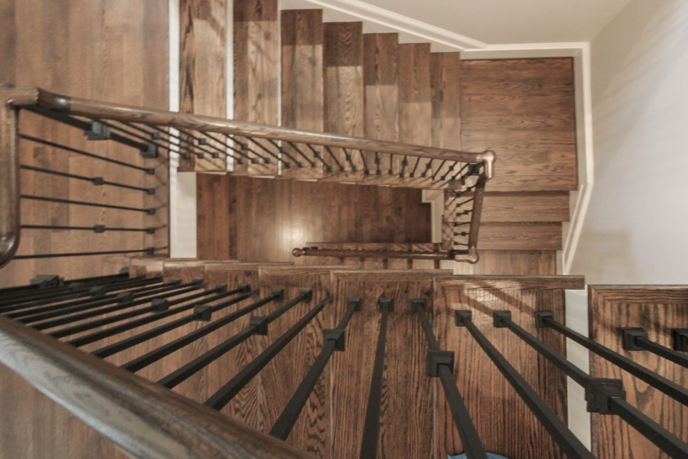 Klassisk inredning av en stor flytande trappa i trä, med sättsteg i målat trä och räcke i metall