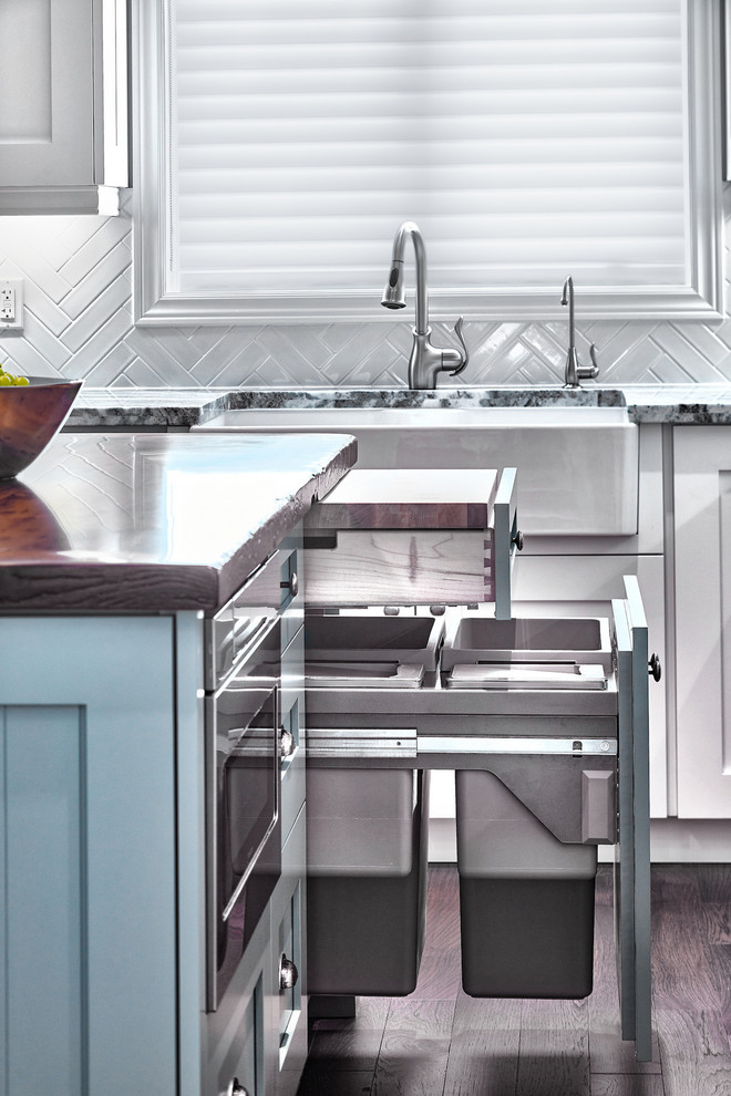 Bild på ett stort vintage kök och matrum, med en rustik diskho, skåp i shakerstil, vita skåp, granitbänkskiva, vitt stänkskydd, stänkskydd i tunnelbanekakel, rostfria vitvaror, mellanmörkt trägolv och en köksö