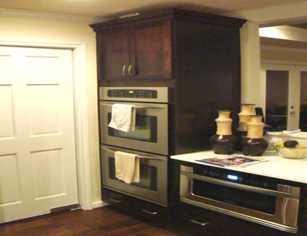 Inspiration for a large transitional u-shaped medium tone wood floor and brown floor eat-in kitchen remodel in Houston with a double-bowl sink, raised-panel cabinets, dark wood cabinets, quartz countertops, white backsplash, ceramic backsplash, stainless steel appliances and no island