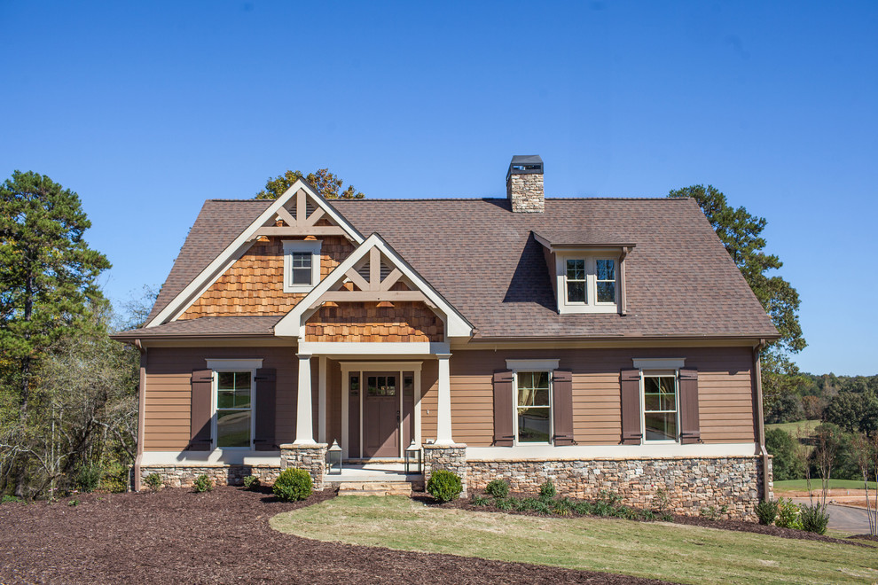This is an example of a large traditional two-storey beige house exterior in Atlanta with mixed siding, a shingle roof and a hip roof.