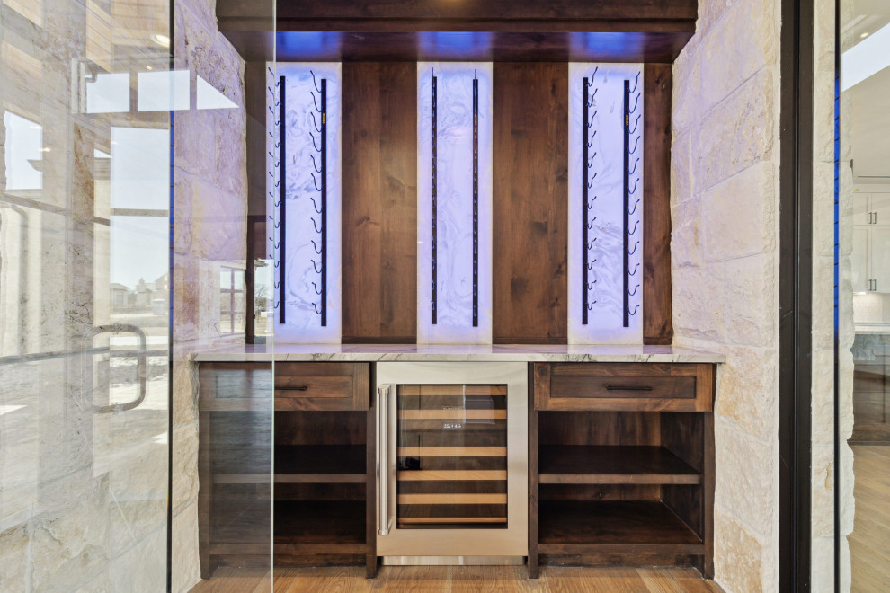 Mittelgroßer Moderner Weinkeller mit braunem Holzboden, Kammern und beigem Boden in Dallas