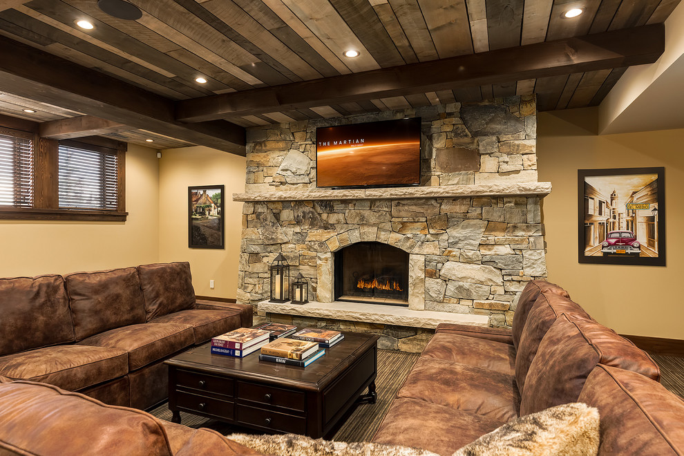 Large arts and crafts open concept family room in Calgary with yellow walls, carpet, a standard fireplace, a stone fireplace surround and a wall-mounted tv.