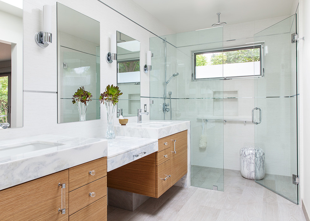 Inspiration for an expansive modern master bathroom in San Francisco with flat-panel cabinets, medium wood cabinets, a curbless shower, a one-piece toilet, gray tile, porcelain tile, white walls, porcelain floors and an undermount sink.