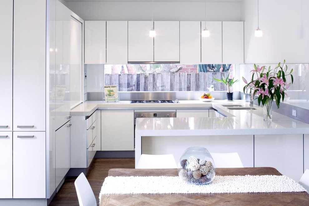Design ideas for a small contemporary kitchen in Other with an undermount sink, white cabinets, quartz benchtops, white splashback, glass sheet splashback and light hardwood floors.