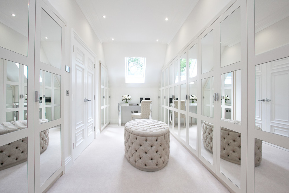 Inspiration for a large traditional women's dressing room in Berkshire with white cabinets and carpet.