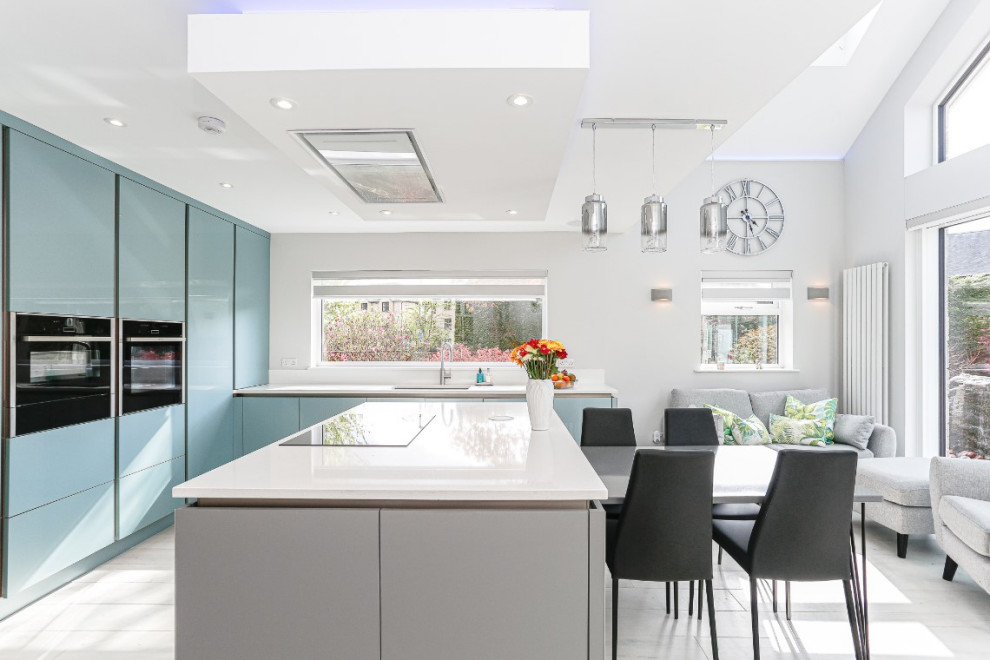 Idee per una cucina moderna di medie dimensioni con ante lisce, ante blu, elettrodomestici neri, pavimento grigio, top bianco e lavello integrato