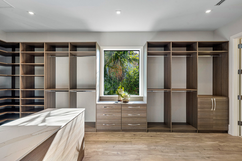Inspiration for a contemporary gender-neutral storage and wardrobe in Miami with open cabinets, medium wood cabinets, medium hardwood floors and brown floor.
