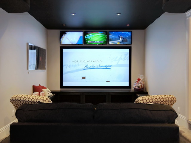 Photo of a mid-sized arts and crafts open concept home theatre in Calgary with grey walls, carpet and a built-in media wall.