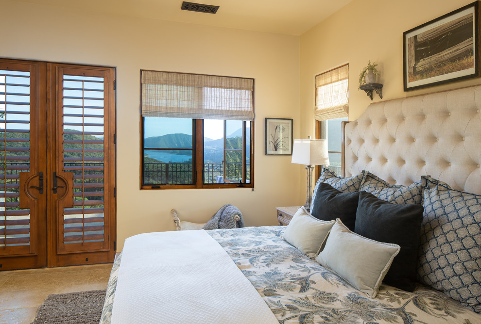 Photo of an expansive mediterranean guest bedroom in San Diego with beige walls, limestone floors and beige floor.