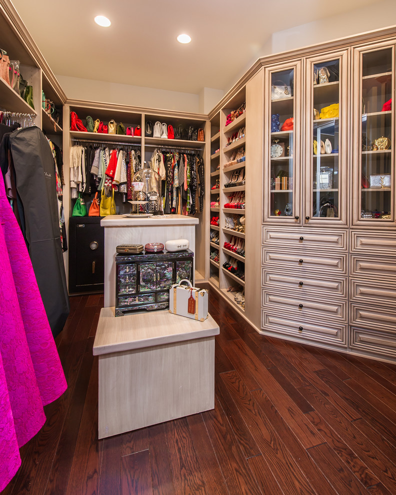 Design ideas for a large mediterranean women's walk-in wardrobe in Los Angeles with raised-panel cabinets, light wood cabinets and dark hardwood floors.