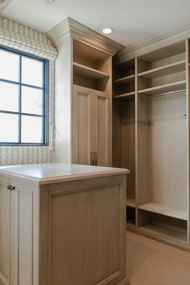 Walk-in closet - mid-sized carpeted walk-in closet idea in Phoenix with open cabinets and beige cabinets
