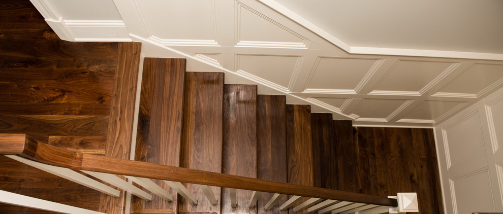 This is an example of a large arts and crafts wood u-shaped staircase in DC Metro with painted wood risers.