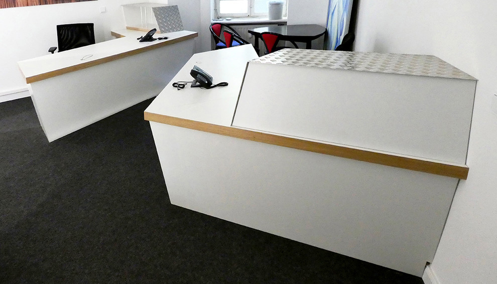Modernes Arbeitszimmer mit Arbeitsplatz, weißer Wandfarbe, Teppichboden, freistehendem Schreibtisch und grauem Boden