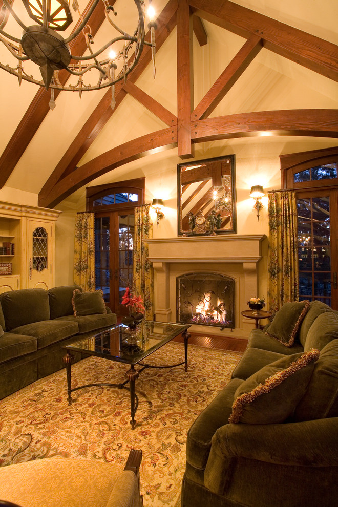 Large traditional formal open concept living room in Other with yellow walls, medium hardwood floors, a standard fireplace, a stone fireplace surround, a built-in media wall and brown floor.