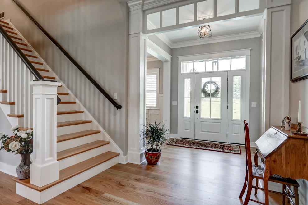 Inspiration for a craftsman brown floor foyer remodel with gray walls and a white front door