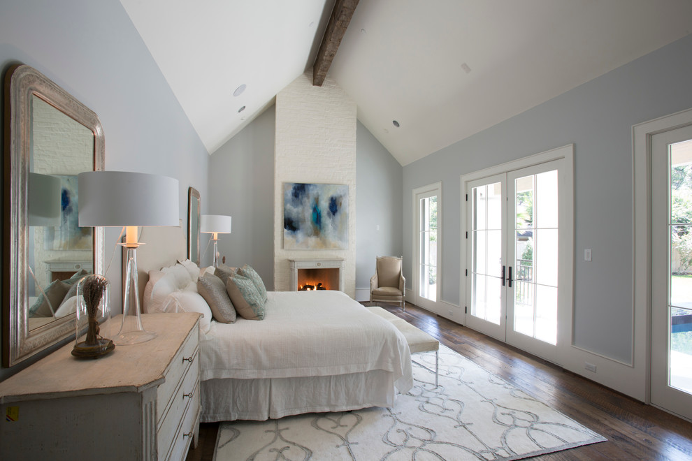 Inspiration for a mid-sized shabby-chic style master bedroom in Houston with dark hardwood floors, a standard fireplace, a stone fireplace surround and grey walls.