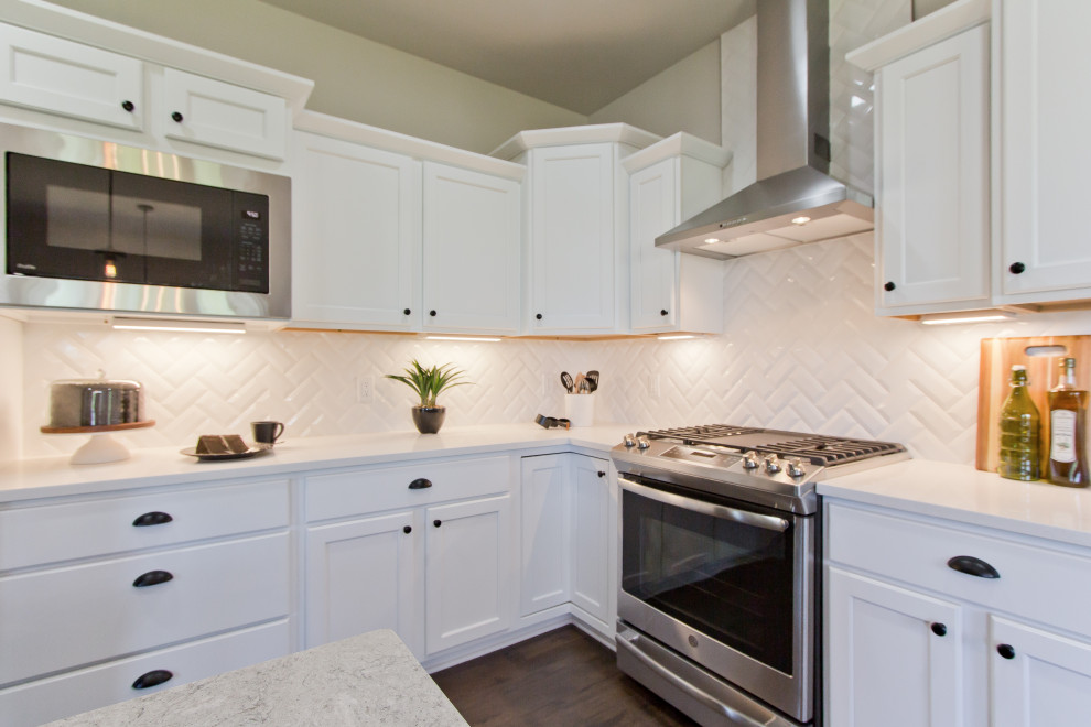 Eat-in kitchen - transitional l-shaped laminate floor and brown floor eat-in kitchen idea with an undermount sink, recessed-panel cabinets, white cabinets, quartz countertops, white backsplash, subway tile backsplash, stainless steel appliances, an island and white countertops