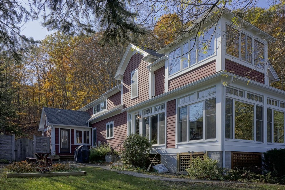 This is an example of a large country three-storey red exterior in New York with wood siding and a gable roof.