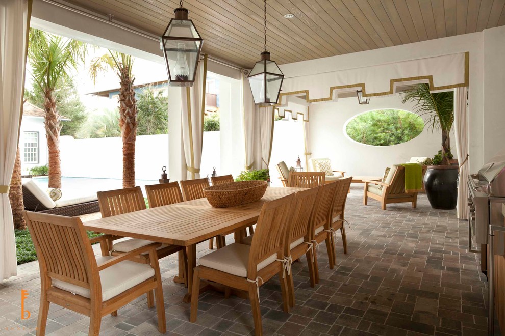 Inspiration for an expansive beach style backyard verandah in Miami with natural stone pavers and a roof extension.