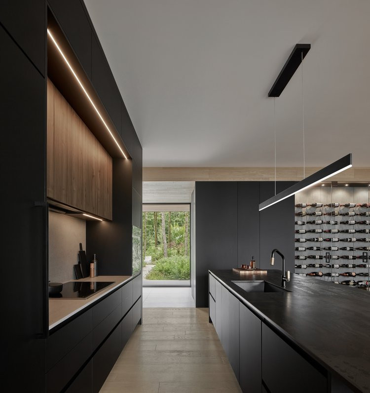 Inspiration for an expansive modern galley eat-in kitchen in Montreal with flat-panel cabinets, black cabinets and with island.