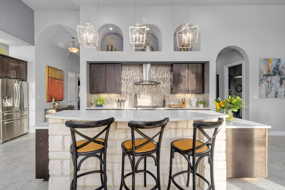 Transitional l-shaped gray floor kitchen photo in Austin with shaker cabinets, dark wood cabinets, gray backsplash, mosaic tile backsplash, stainless steel appliances, an island and white countertops