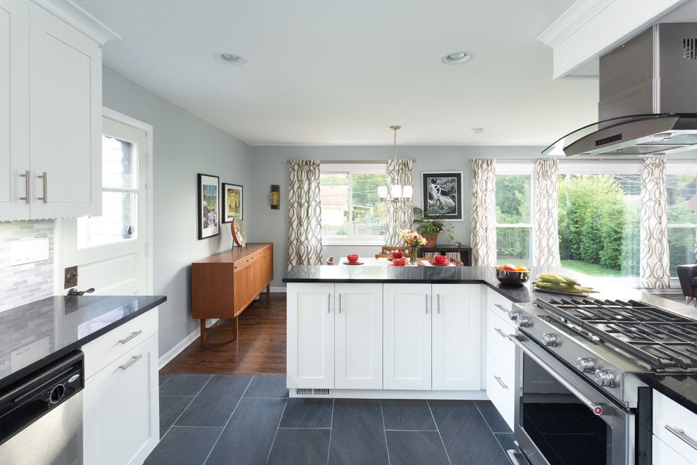 Inspiration for a large transitional l-shaped medium tone wood floor open concept kitchen remodel in Chicago with an undermount sink, shaker cabinets, white cabinets, granite countertops, multicolored backsplash, ceramic backsplash, stainless steel appliances and no island