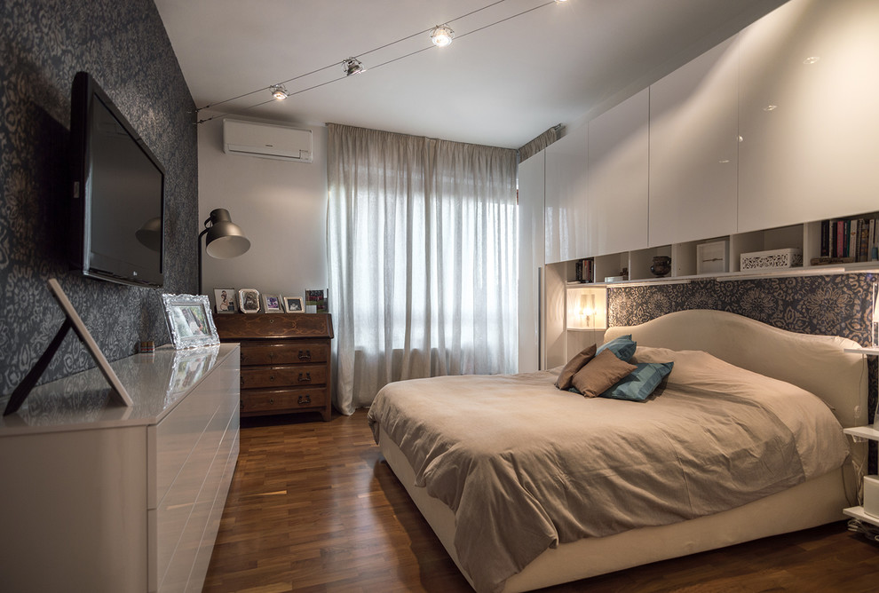 Mid-sized modern master bedroom in Turin with multi-coloured walls and dark hardwood floors.