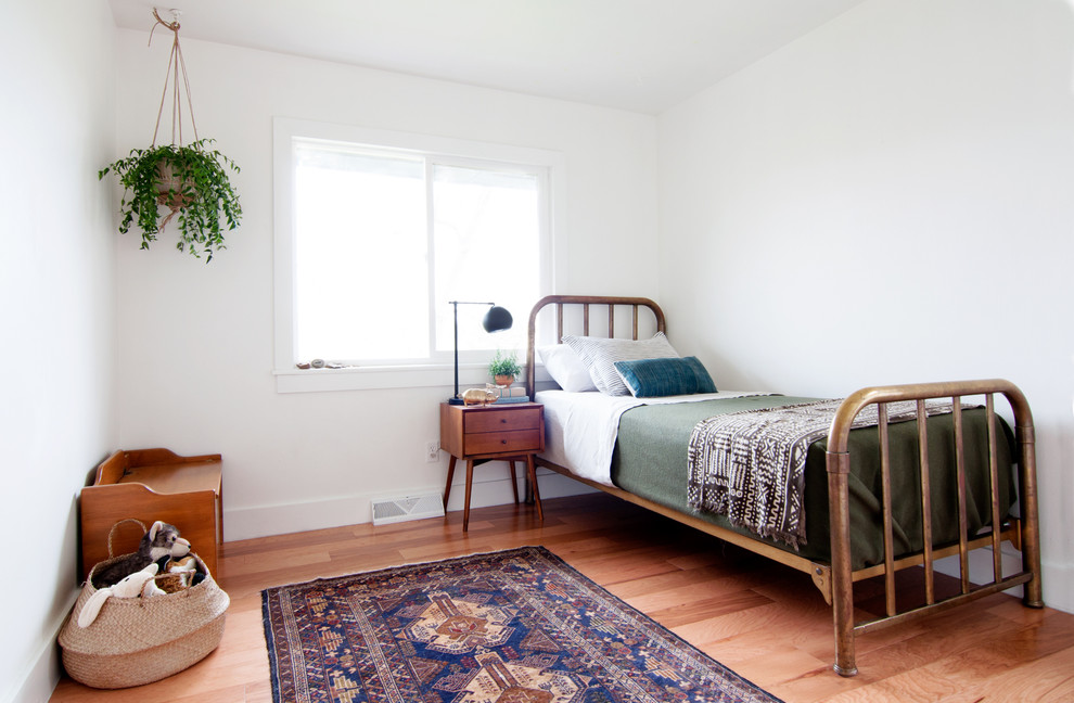 This is an example of a mid-sized midcentury gender-neutral kids' bedroom for kids 4-10 years old in Denver with white walls and light hardwood floors.